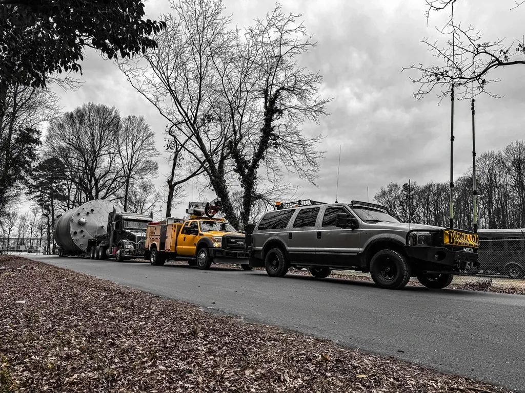 Multiple escort vehicles aligned with heavy haul tractors for coordinated oversized transport.